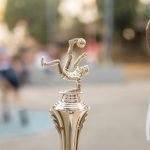 Troféu dourado de futebol com fitas, exposto como símbolo de vitória e premiação esportiva.